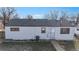 Rear exterior view of a white one-story home with a well-kept lawn at 1345 S Meade St, Denver, CO 80219