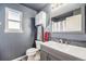 Stylish bathroom with gray walls, modern vanity, gray subway tile backsplash, and wood look tile floors at 11363 Jersey St, Thornton, CO 80233