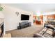 Inviting living room open to the kitchen, featuring a fireplace, large screen tv, and comfortable leather sofa at 11363 Jersey St, Thornton, CO 80233