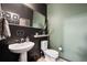 Stylish powder room features contrasting walls, modern fixtures, and a unique decorative mirror at 12264 Olive Way, Thornton, CO 80602