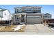 Charming two-story home featuring a stone-accented facade, well-manicured lawn, and an attached two-car garage at 12264 Olive Way, Thornton, CO 80602