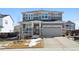 Two-story home with stone accents, gray siding, covered porch, and attached two-car garage at 12264 Olive Way, Thornton, CO 80602