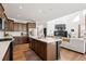 Open-concept kitchen with a central island, stainless steel appliances, and hardwood floors at 12264 Olive Way, Thornton, CO 80602