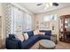 Cozy living room featuring a comfortable blue sectional sofa and plenty of natural light at 12264 Olive Way, Thornton, CO 80602
