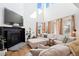 Bright living room featuring high ceilings, a fireplace, and large windows at 12264 Olive Way, Thornton, CO 80602