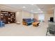 Open basement space with neutral carpeting, a futon sofa, and plenty of room for activities at 1898 Wilson Cir, Erie, CO 80516