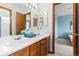 Bright bathroom with double sinks, wood cabinets, large mirror, and light fixtures at 1898 Wilson Cir, Erie, CO 80516