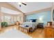 Large bedroom suite with a bay window, hardwood floors, and light blue accent wall at 1898 Wilson Cir, Erie, CO 80516