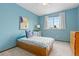 Cozy bedroom with a twin bed, a window, light-blue colored walls, and gray carpet at 1898 Wilson Cir, Erie, CO 80516