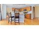 Updated kitchen features wood cabinets, stainless appliances, breakfast bar with seating, and modern lighting at 1898 Wilson Cir, Erie, CO 80516