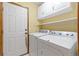 Practical laundry room offers side-by-side washer and dryer, ample storage, and easy backyard access at 1898 Wilson Cir, Erie, CO 80516