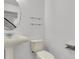 Cozy powder room featuring pedestal sink, toilet, and modern shelving with mirror at 1385 Candleglow St, Castle Rock, CO 80109