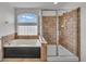 Beautiful bathroom offering a walk-in shower and soaking tub with natural light at 1385 Candleglow St, Castle Rock, CO 80109