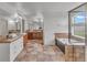 Bright bathroom featuring a double vanity, soaking tub, tiled shower, and tile flooring at 1385 Candleglow St, Castle Rock, CO 80109