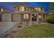 Charming home exterior with stone accents, a well-manicured lawn, and a three-car garage at 1385 Candleglow St, Castle Rock, CO 80109
