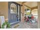 Inviting front porch with brick flooring, comfortable seating, decorative plants, and a stylish front door at 1385 Candleglow St, Castle Rock, CO 80109