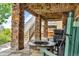 Covered patio with stone fireplace, wooden chairs, and a view of the back yard at 1385 Candleglow St, Castle Rock, CO 80109
