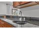 Close-up of the wet bar, highlighting the black granite countertop and stainless steel faucet fixture at 1385 Candleglow St, Castle Rock, CO 80109
