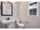 Small bathroom featuring pedestal sink, toilet, and window allowing for natural light at 24661 E 33Rd Dr, Aurora, CO 80019