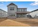 A charming two-story gray home with a covered porch, large windows, and stone accents, set against a clear blue sky at 24661 E 33Rd Dr, Aurora, CO 80019