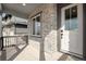Close-up of front porch showing brick detail, white door with glass window, and corner view at 24661 E 33Rd Dr, Aurora, CO 80019