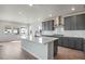 Bright and airy kitchen featuring a large island, gray cabinets, stainless vent hood, and lots of natural light at 24661 E 33Rd Dr, Aurora, CO 80019