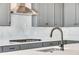 Close-up of modern kitchen with gray cabinets, stainless steel appliances, and a black faucet at 24661 E 33Rd Dr, Aurora, CO 80019