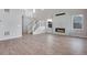 Bright living room with fireplace, modern white staircase, and wood-look floors at 24661 E 33Rd Dr, Aurora, CO 80019