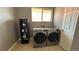 Functional laundry room featuring side-by-side washer and dryer and a small storage shelf at 1469 S Reed St, Lakewood, CO 80232