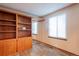 Bedroom featuring built-in bookshelves, mirrors, and a bright window at 2707 S Richfield St, Aurora, CO 80013