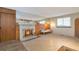Bright living room with a white brick fireplace, wooden accent wall, and large mirror above at 2707 S Richfield St, Aurora, CO 80013