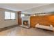 Cozy living room featuring a white brick fireplace, wood accent wall, and ample natural light at 2707 S Richfield St, Aurora, CO 80013
