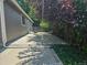 Long concrete patio runs the length of the side of the home, with mature plantings at the fence line at 2707 S Richfield St, Aurora, CO 80013