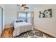 Bright bedroom with hardwood floors, ceiling fan, and white bedding, bathed in natural light at 433 S Xavier St, Denver, CO 80219