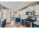 Bright kitchen with stainless appliances, contrasting cabinetry, and a view into dining area at 433 S Xavier St, Denver, CO 80219
