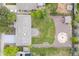 Aerial view of a home with green lawn, gravel area, fire pit, pergola, and lush landscaping at 6147 Dunraven St, Golden, CO 80403