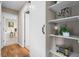 Hallway with hardwood floors, storage shelves, and a sliding door at 6147 Dunraven St, Golden, CO 80403