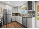 Modern kitchen with stainless steel appliances, granite countertops, and hardwood floors at 6147 Dunraven St, Golden, CO 80403
