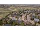 Aerial shot of a neighborhood with houses nestled among mature trees near open spaces at 556 Rachael Pl, Castle Pines, CO 80108