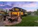 Relaxing backyard showing a patio with outdoor seating and a fire pit under string lights at 556 Rachael Pl, Castle Pines, CO 80108