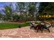 Spacious backyard with a stone patio, outdoor seating, and lush green landscaping at 556 Rachael Pl, Castle Pines, CO 80108