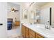 Bright bathroom features double sinks, wood cabinets and views to the bedroom at 556 Rachael Pl, Castle Pines, CO 80108