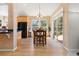 Bright dining area featuring hardwood floors, modern lighting, sliding glass doors to a patio and adjacent to kitchen at 556 Rachael Pl, Castle Pines, CO 80108
