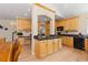Large kitchen featuring wood cabinets, granite countertops, stainless steel appliances, and adjacent desk area at 556 Rachael Pl, Castle Pines, CO 80108