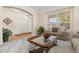 Cozy living area with glass coffee table, sofa with decorative pillows, and natural light at 556 Rachael Pl, Castle Pines, CO 80108
