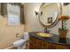 Elegant powder room features a pedestal sink with ornate details, a decorative mirror and stylish fixtures at 556 Rachael Pl, Castle Pines, CO 80108