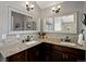 Primary bathroom featuring granite countertops, double sinks, and decorative framed mirrors at 8425 Green Island Cir, Lone Tree, CO 80124