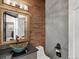 Stylish powder room showcasing a bowl sink, wood tile accent wall, and designer fixtures at 8425 Green Island Cir, Lone Tree, CO 80124