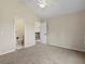 Bedroom with neutral paint, carpet, ceiling fan, and doors leading to a bathroom at 8425 Green Island Cir, Lone Tree, CO 80124
