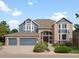 Charming two-story home featuring a three car garage and a brick archway leading to the main entrance at 8425 Green Island Cir, Lone Tree, CO 80124